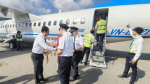 Mr. Le Hoang Hai, Secretary of the Con Dao Party Committee, presents flowers to the first visitors arriving at Co Ong Airport on the first day of 2026.