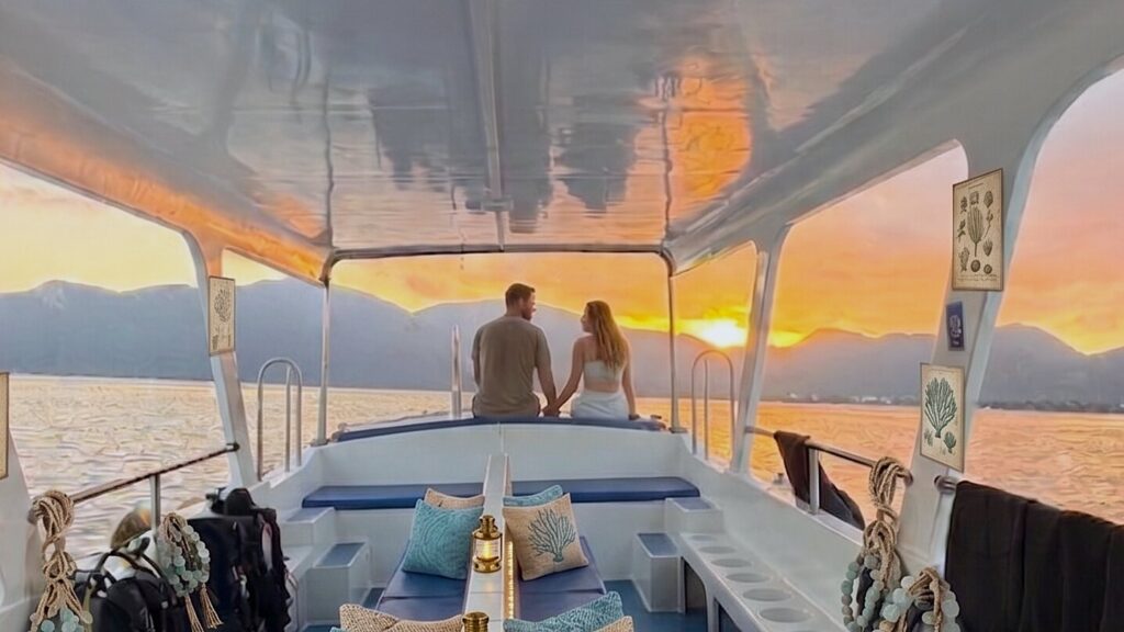 Couple enjoying a private snorkeling experience boat at sunset in Con Dao Vietnam with calm ocean and island views